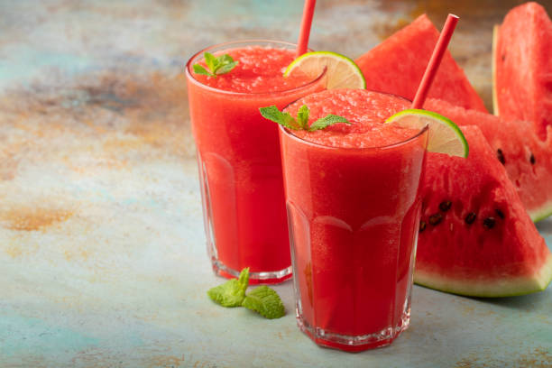 istock Watermelon slushie with lime, summer refreshing drink in tall glasses on a blue rusty background. with copy space 1006352918