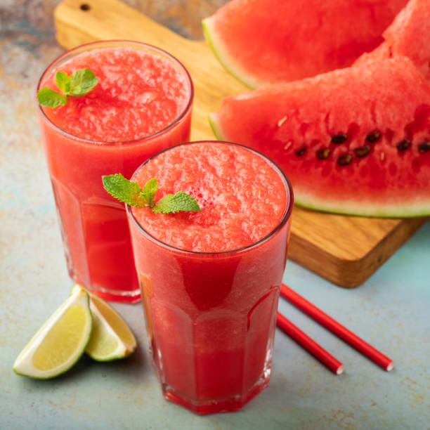 istock Watermelon slushie with lime, summer refreshing drink in tall glasses on a blue rusty background 1006352926