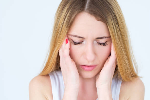 istock emotion face headache fatigue tired woman temples 1006374388