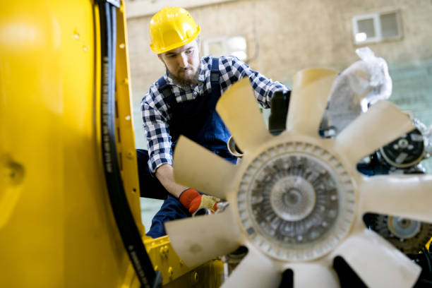 istock Serious confident young man in yellow hardhat examining engineering vehicle and holding expertise to find out breakdown 1006378832