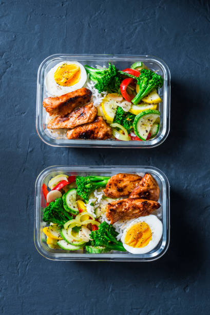 istock Rice, stewed vegetables, egg, teriyaki chicken - healthy balanced lunch box on a dark background, top view. Home food for office concept 1006387046