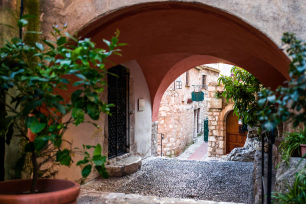 A view of one of the small alleyways and old cobble stone and architecture of the village of Eze. Framed with the arch architecture and greenery that cover the entire village.