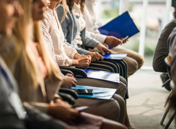 istock Group of unrecognizable business people in a row on a seminar. 1006423584