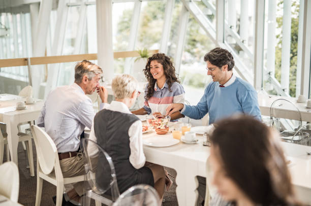 istock Group of happy business people communicating while having lunch break in cafeteria. 1006423616