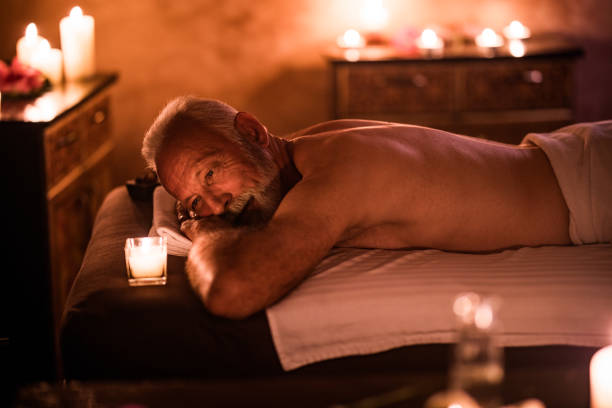 istock Smiling senior man relaxing on a massage bed at the spa. 1006439378