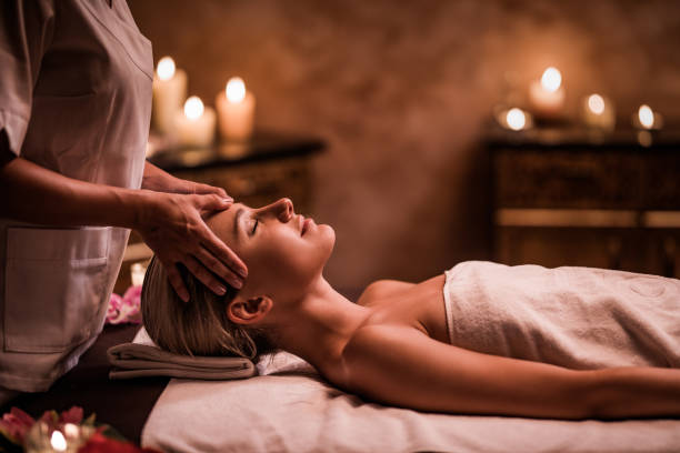 Young woman having facial massage at the health spa. Woman enjoying in head massage during beauty treatment in the spa. facial massage stock pictures, royalty-free photos & images