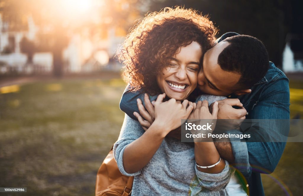 You kisses still give me butterflies Shot of an affectionate young couple bonding together outdoors Couple - Relationship Stock Photo