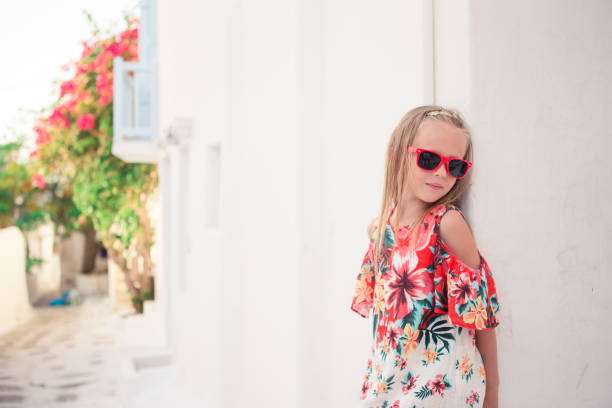 istock Girl in white dresses having fun outdoors on Mykonos streets 1006459906
