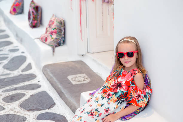 istock Girl in white dresses having fun outdoors on Mykonos streets 1006460108