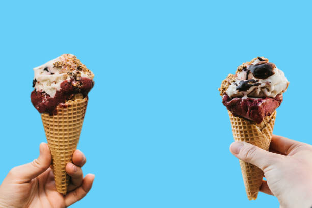 istock People are holding ice cream on a blue background. Creative idea in a minimal style. Concept of the holiday. In the middle is space for text 1006465818