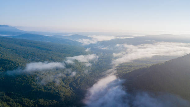 istock Epic Aerial Flight Through Mountain Clouds on Sunrise Beautiful Morning. 1006469018