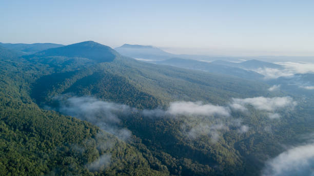 istock Epic Aerial Flight Through Mountain Clouds on Sunrise Beautiful Morning. 1006469252