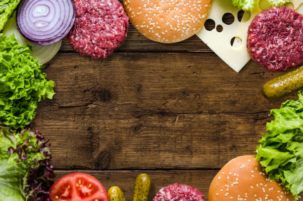 istock Hamburger ingredients on wooden background, menu mock up template 1006474792