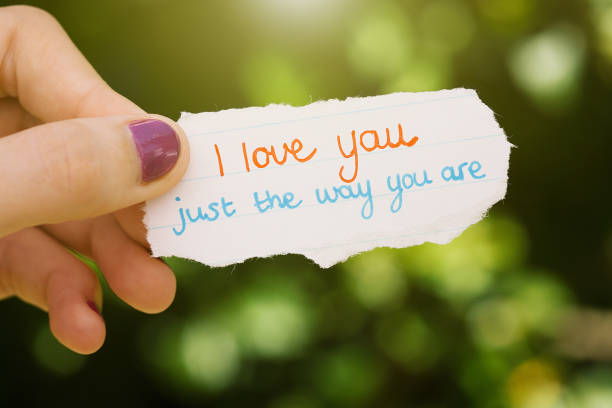 istock Female hand holds out hand-written love note 1006477438