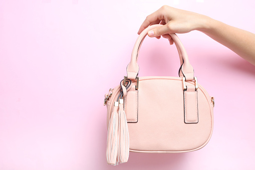 Female bag in hand on a pink background