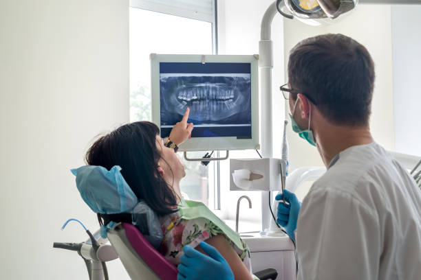 istock Dentist and patient looking at x-ray of teeth on screen 1006477612