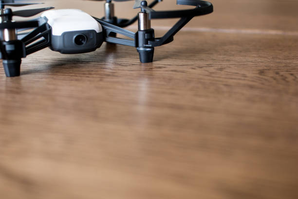 Mini black and white indoor drone on a wooden table.