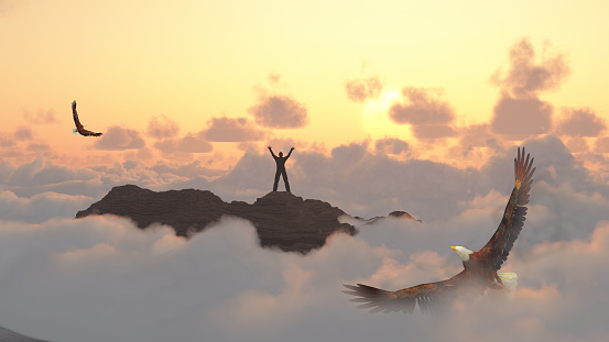 Man on a mountain peak. Eagle flies above clouds.