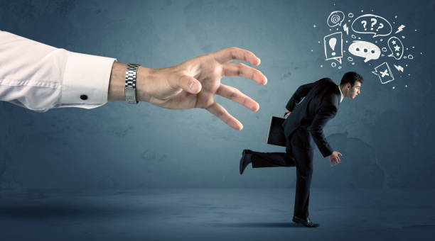 istock Business man running from a big hand 1006496476