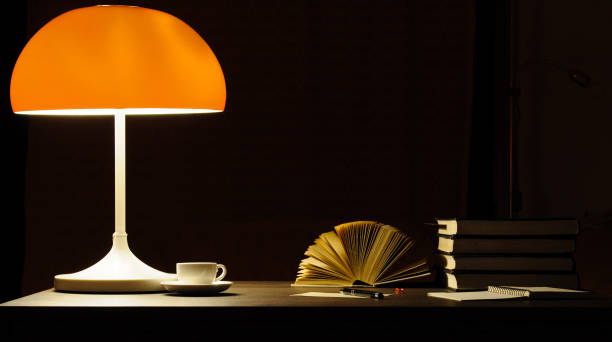 istock A table lamp lights up the books on the desk 1006496812