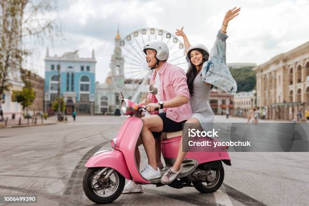 Optimistic Jolly Couple Riding In City Stock Photo - Download Image Now - Motor Scooter, Couple - Relationship, Millennial Generation