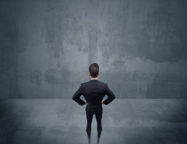 istock Businessman standing in front of urban wall 1006500130