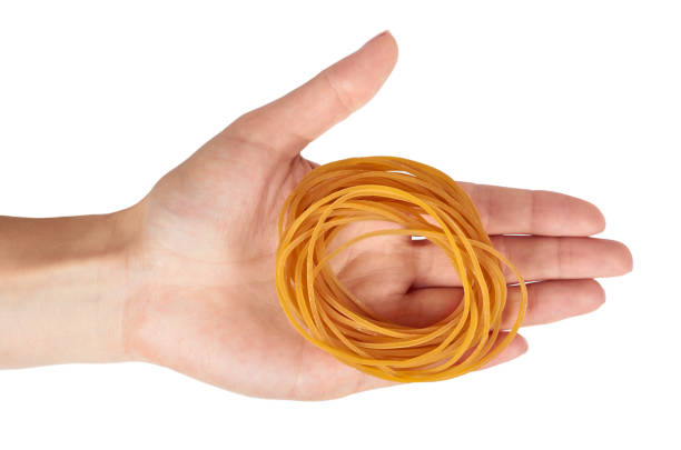 istock Yellow rubber bands close up with hand isolated on white background. 1006500254
