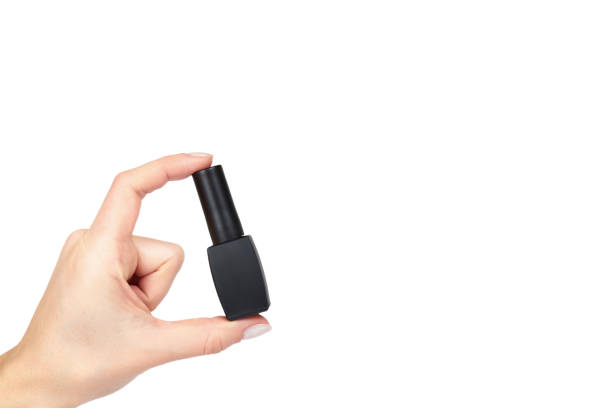 istock Black nail polish bottle with hand isolated on white background, copy space template 1006503152