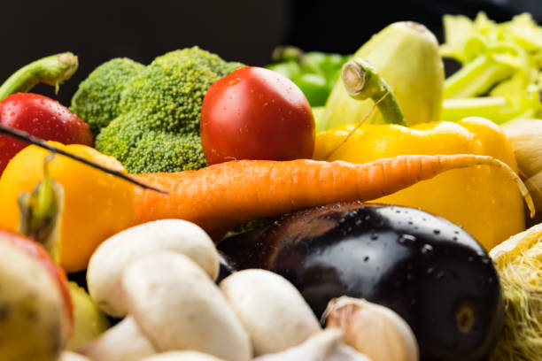 Locally grown bell pepper, corn, carrot, mushrooms and other natural vegan food laying on table