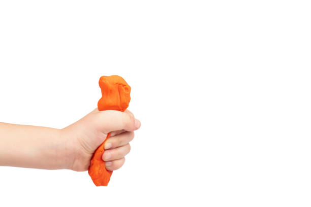 istock Orange plasticine bar with kid hand, isolated on white background. copy space template 1006503648