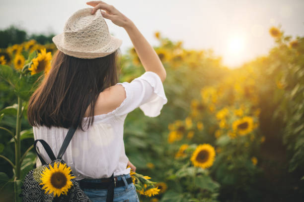 istock Woman enjoys in sunflower field 1006503790