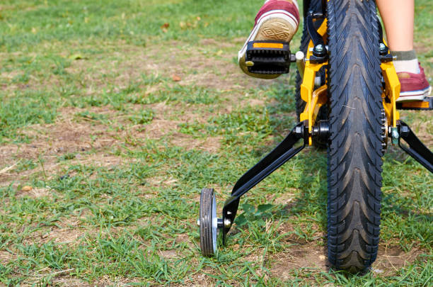 istock Boy on kids yellow bicycle in park studies to ride 1006504320