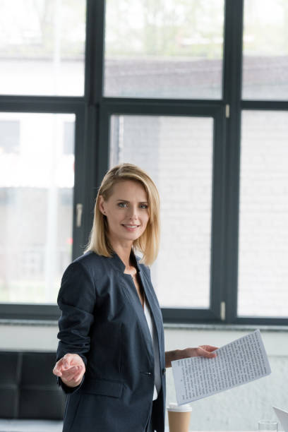 istock attractive businesswoman holding documents and gesturing in office 1006507522