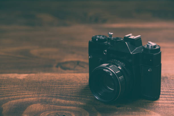 istock Vintage film camera on wooden background with copy space 1006507694