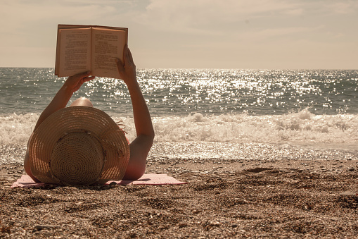 Beautiful woman reading a book on beach AntalyaBeautiful woman reading a book on beach Antalya