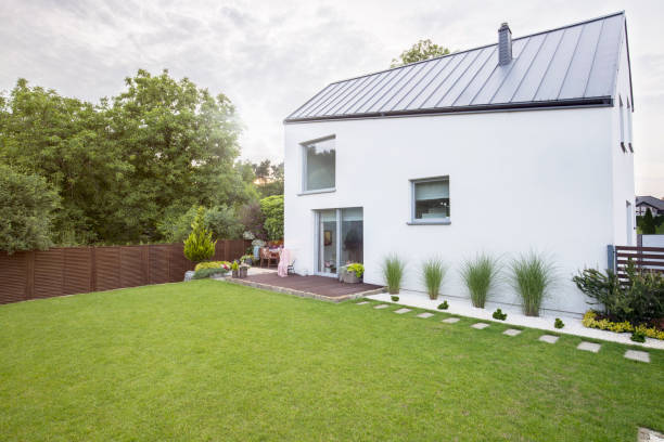istock White house with spacious garden and green grass during spring. Real photo 1006511650