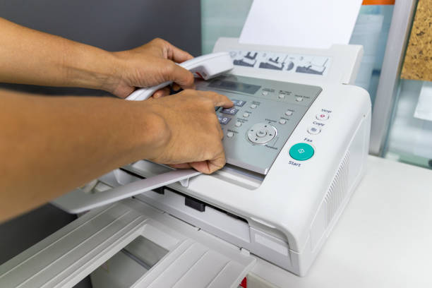 istock hand man are using a fax machine in the office Business concept 1006512248