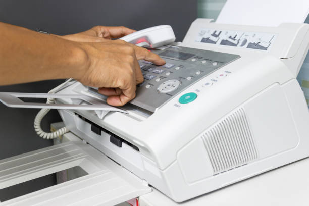 istock hand man are using a fax machine in the office Business concept 1006512258