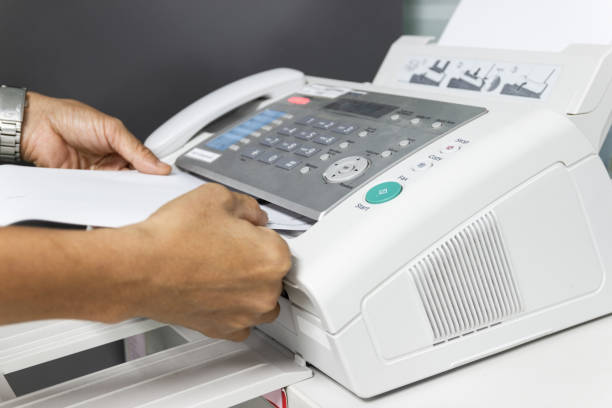 istock hand man are using a fax machine in the office Business concept 1006512466