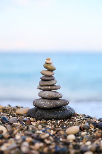 istock Stones balance and wellness retro spa concept. Close-up pyramid from stones stack over sea. Clear color. 1006525496
