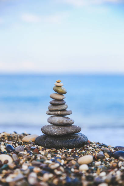 istock Stones balance and wellness retro spa concept. Close-up pyramid from stones stack over sea. Easy toning 1006525542