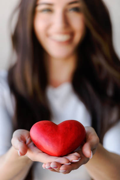 coeur rouge sur les paumes de la femme. symbole de l’amour - beautiful caucasian one person romance photos et images de collection