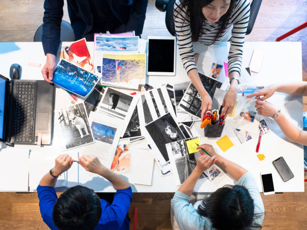 Magazine Editors At Work. Magazine editors brainstorming in the office. Discussing and looking for new ideas for their magazine. photo editor photos stock pictures, royalty-free photos & images