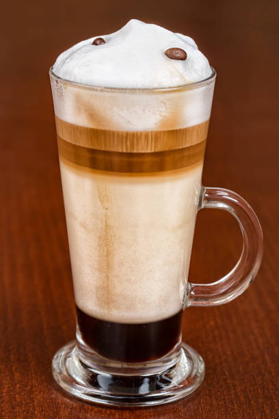 Glass Cup of Latte on the wooden Table. French breakfast in French Flair Macaronnerle Cafe in Heidelberg. Top View. Close-up, Macro.