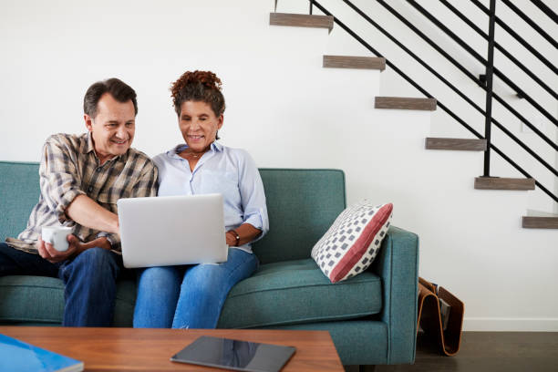 istock Senior Couple Sitting On Sofa At Home Using Laptop Together 1006538166