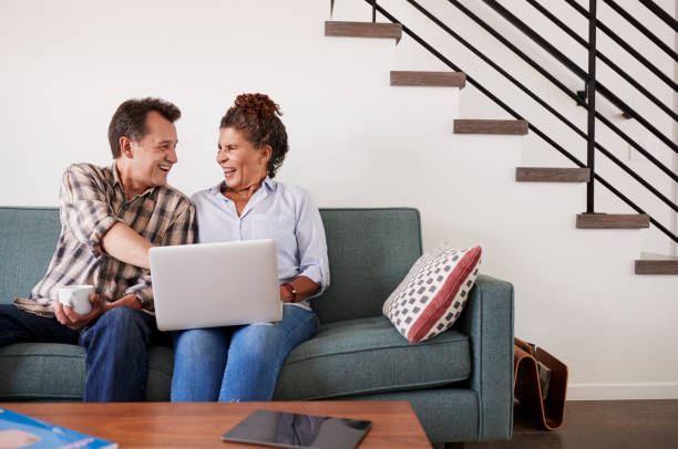 istock Senior Couple Sitting On Sofa At Home Using Laptop Together 1006538254