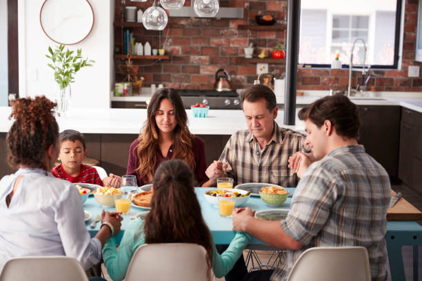 istock Multi Generation Family Praying Before Meal Around Table At Home 1006538256