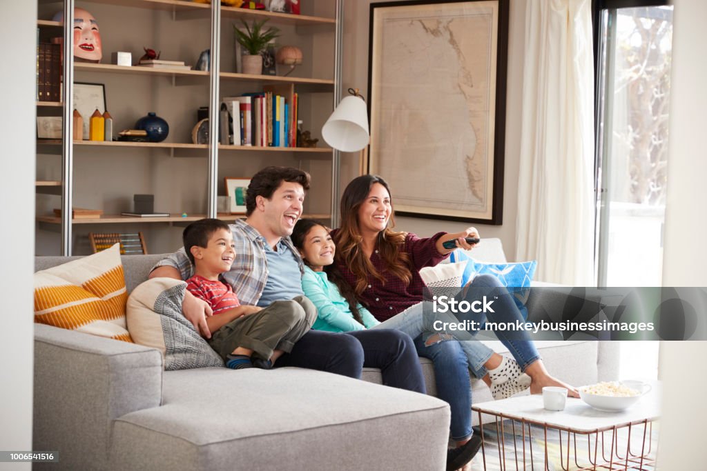 Famille, détente sur le canapé à la maison regarder la télévision - Photo de Famille libre de droits