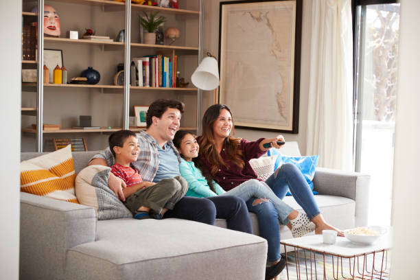 istock Family Relaxing On Sofa At Home Watching Television 1006541516