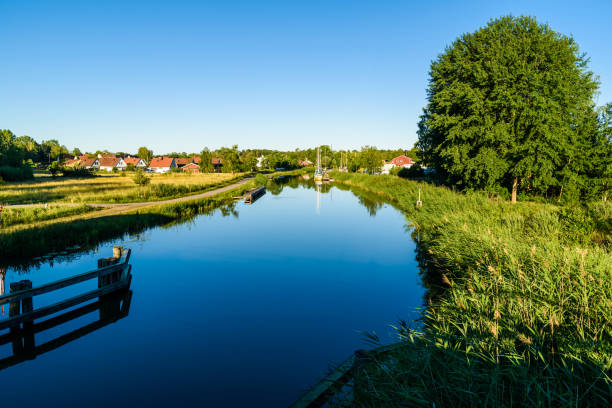 Early morning view of the Gota canal with boats moored at a marina in the distance. Location Norsholm, Sweden.